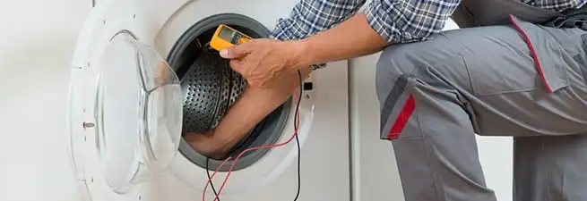 Dryer repair technician inspecting and repairing a clothes dryer in Chula Vista, CA