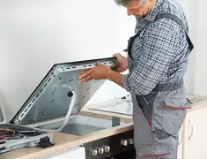 Appliance repair technician installing a built-in cooktop in Chula Vista, CA