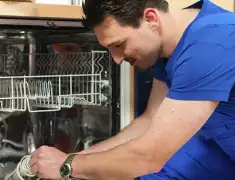Dishwasher repair technician inspecting and servicing an open dishwasher in Chula Vista, CA