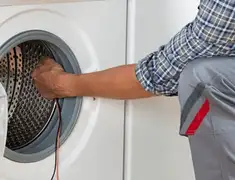 Dryer repair technician diagnosing and servicing a clothes dryer in Chula Vista, CA