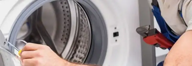 Appliance technician repairing a clothes dryer drum and internal parts in Chula Vista, CA