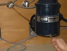 Garbage disposal repair technician tightening the mounting ring under a sink in Chula Vista, CA