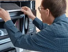 Appliance repair technician replacing a microwave vent filter in Chula Vista, CA