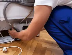 Appliance repair technician fixing refrigerator water line and connections in Chula Vista, CA
