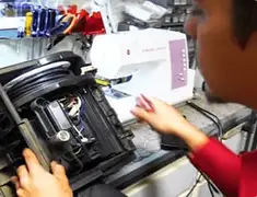 Vacuum repair technician servicing internal components on a workbench in Chula Vista, CA