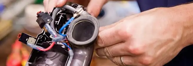 Vacuum repair technician reconnecting wiring and components in Chula Vista, CA