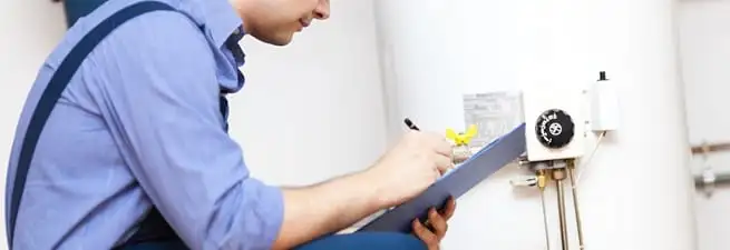 Water heater repair technician inspecting the unit and recording service notes in Chula Vista, CA